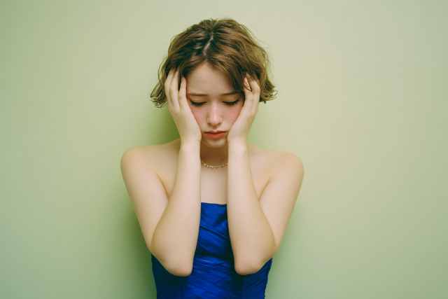 頭を抱えて悩む女性