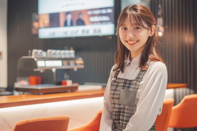 ガールズラウンジのカウンターの前で和顔を見せる若い女性