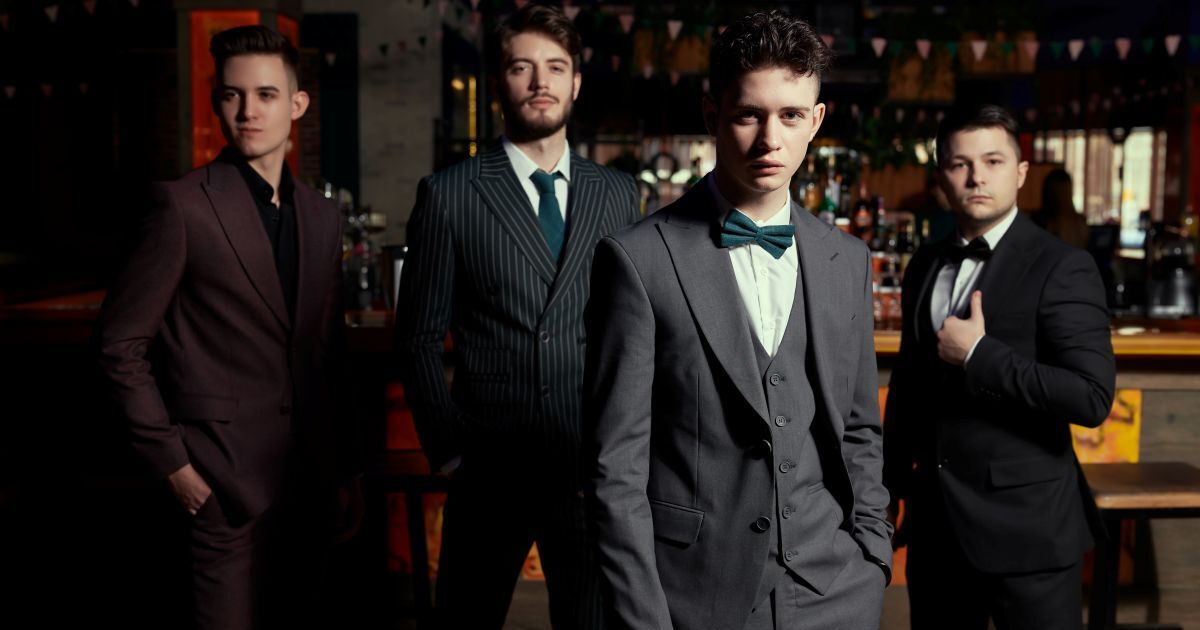 こちらを見るスーツの男性4人