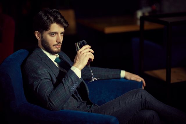 ソファに座りお酒を持つ男性の手