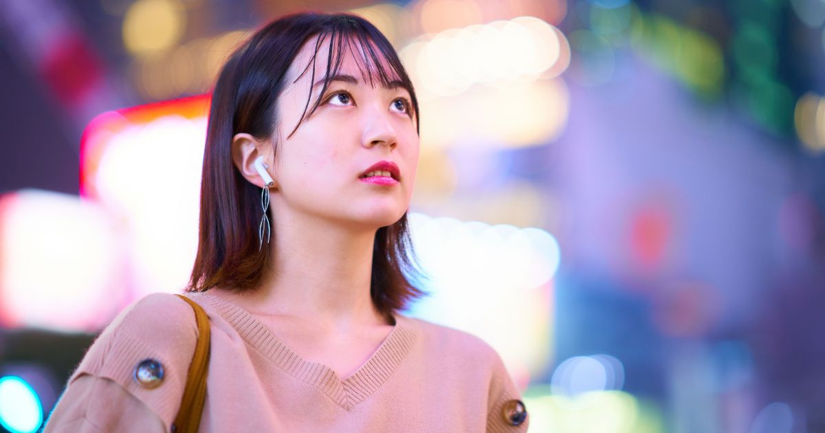 夜の街を歩く若い女性