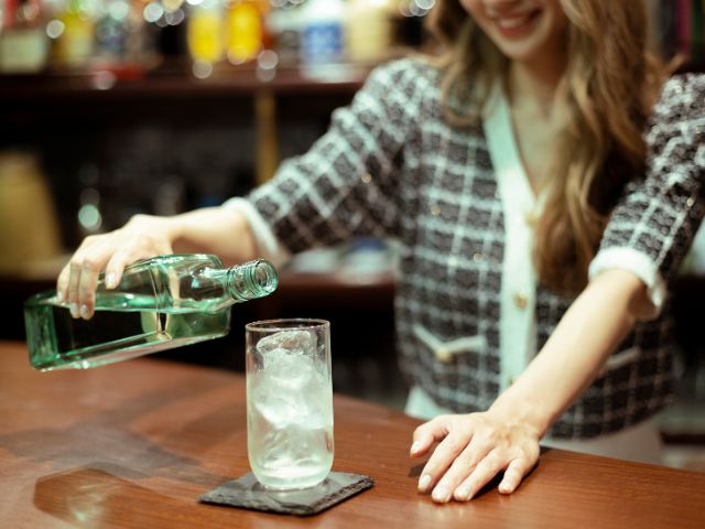 バーカウンター越しにお酒を作ってくれる若い女性