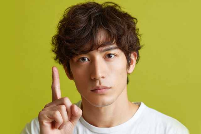 人差し指を立てる男性