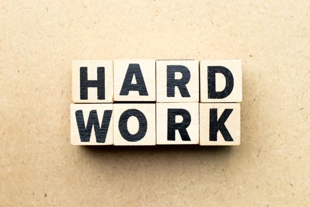 ベージュの背景の前に
あるHARDWORKと書かれたブロック