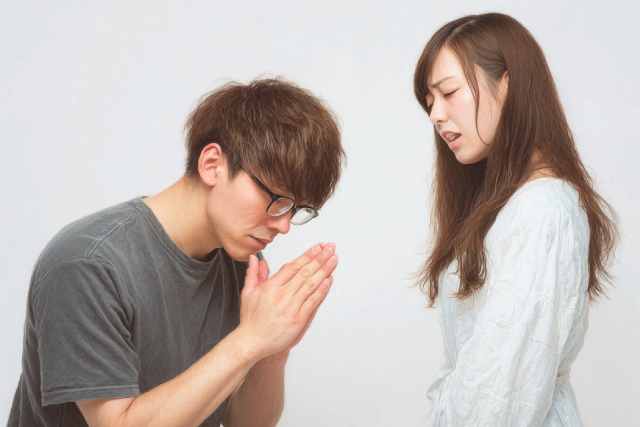 女性に謝っている男性