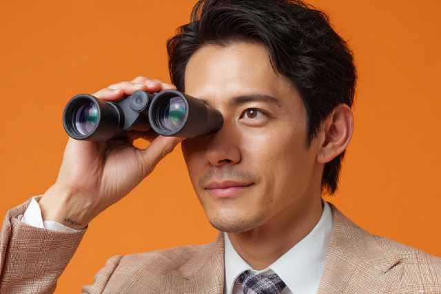 双眼鏡でどこかを見ている男性