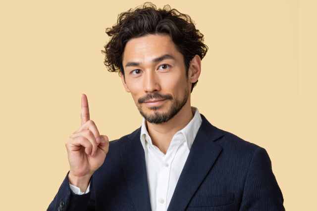人差し指をあげる男性