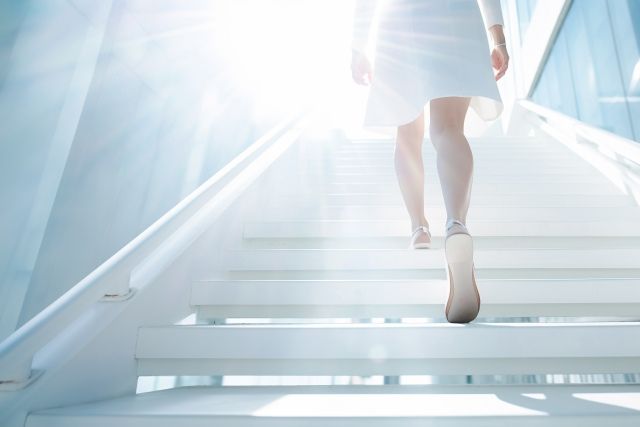 光る階段を昇る女性