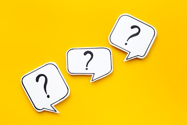 黄色の背景に置かれた3つのハテナマーク