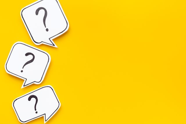 黄色の背景の前にある3つのハテナマーク