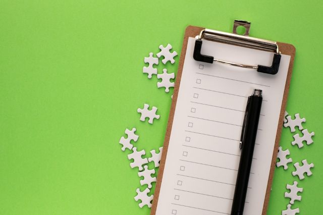 緑の背景の前にあるチェックリストのボード