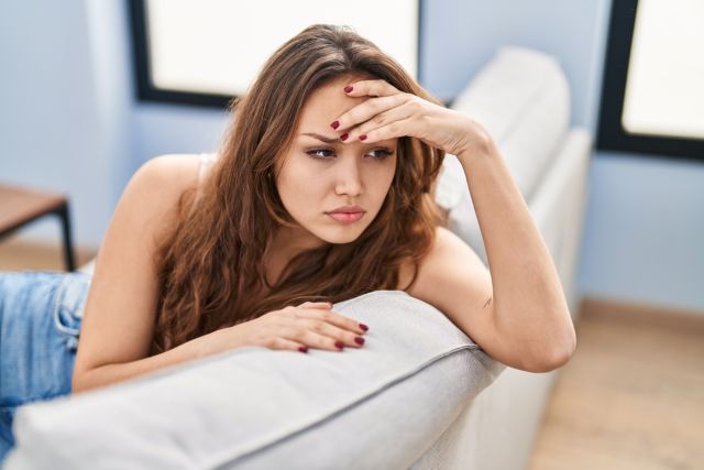 ソファで頭を抱える女性