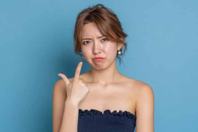 自分を指さして落ち込んでいる女性