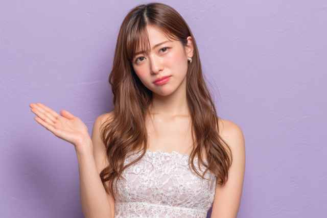 不満そうに案内をする女性