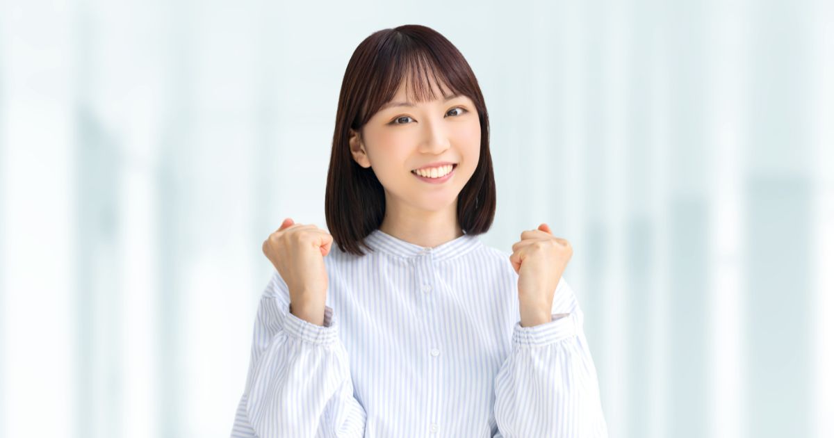 ガッツポーズをする若い女性