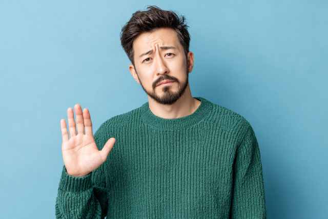 片手を上げる男性