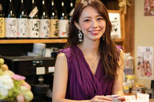 カウンターからこちらを見るスナックのママ