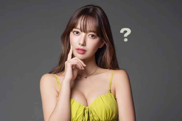 黒い背景の前で何かに悩んでいる黄色いドレスの女性