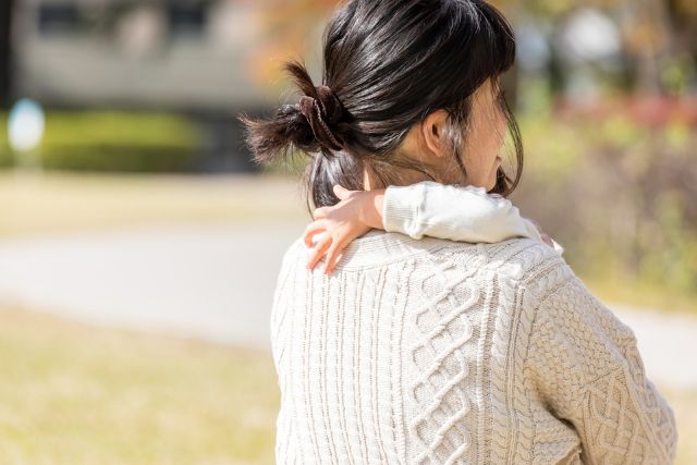 子どもを抱きかかえる女性の後ろ姿