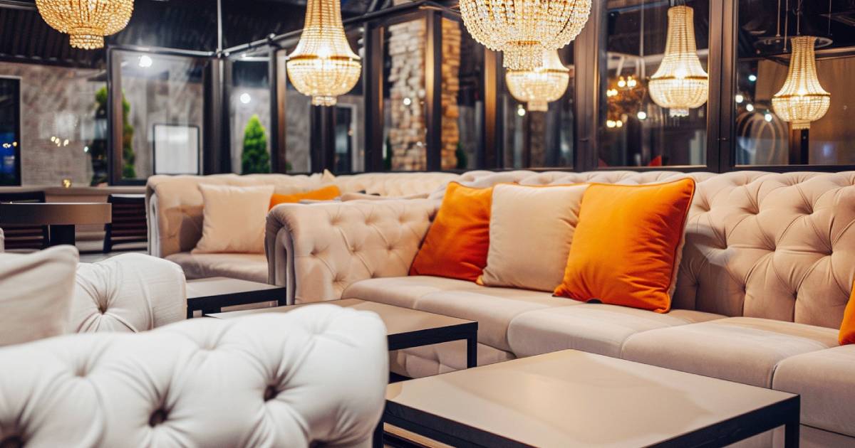 ベージュのソファとオレンジのクッションがおいてあるモダンなラウンジ