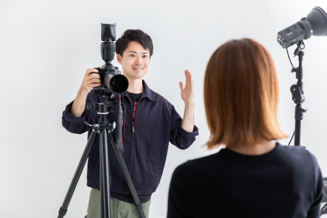 女性にポーズを指示するカメラマン