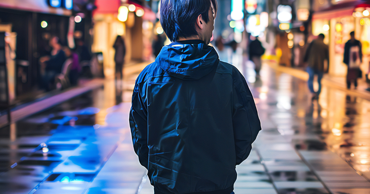 夜の街を徘徊している男性の後ろ姿