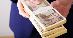 札束をもった男性の手元のクローズアップ