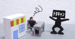 黒い人型ミニチュアの頭にドタキャンの文字