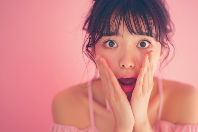 驚いた表情のピンクのドレスを着た若い女性