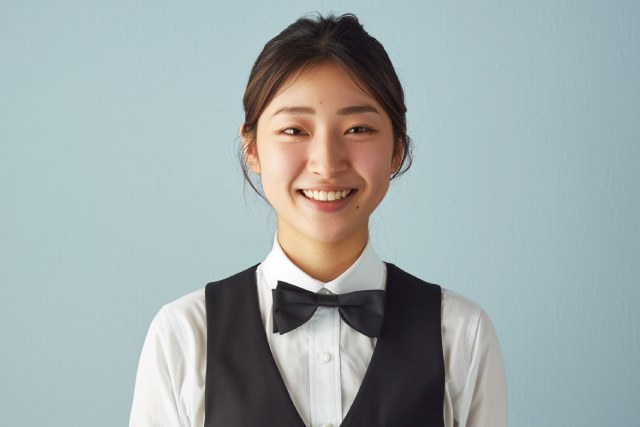 黒いベストを着て黒い蝶ネクタイを付けた女性