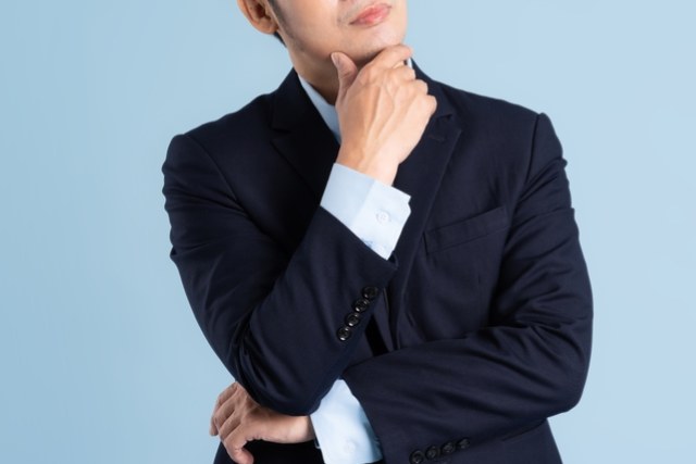 考えている様子のスーツを着た男性