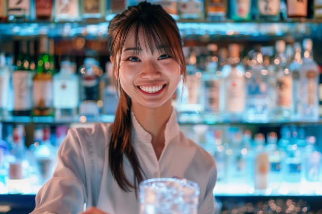 ガールズバーでカクテルを渡す白シャツの女性