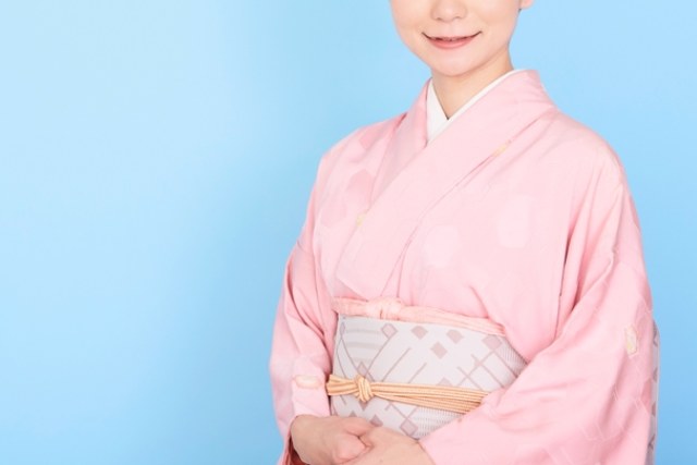 ピンク色の着物をきて微笑む女性