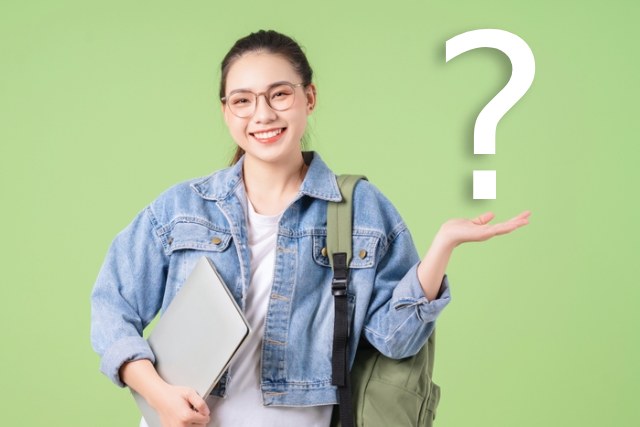 笑っている女子大生の手の平からクエスチョンマークが出ている様子