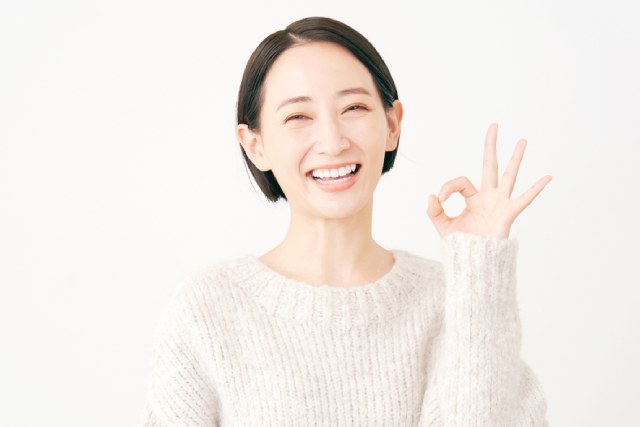 40代のショートカットの日本人女性が指でOKマークを作って笑っている