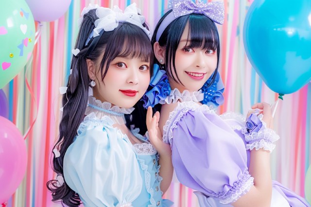 風船が浮かぶカラフルな背景の前に立つ2人のコンカフェ嬢