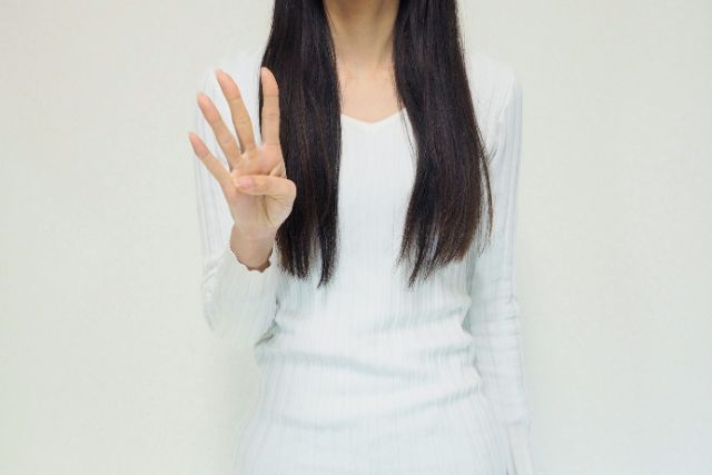 4本指を出す女性