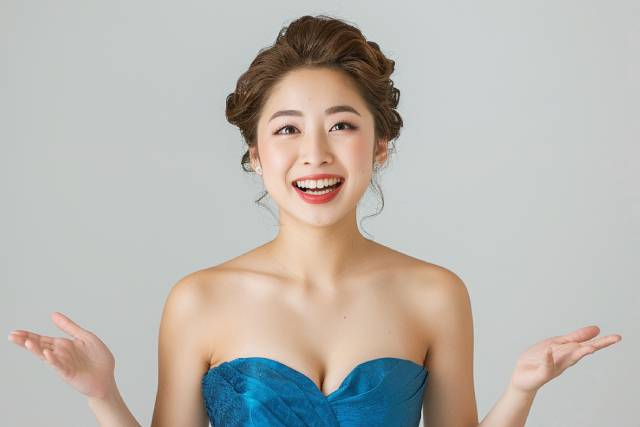 青いドレスを着て両手を嬉しそうに広げる若いキャバ嬢