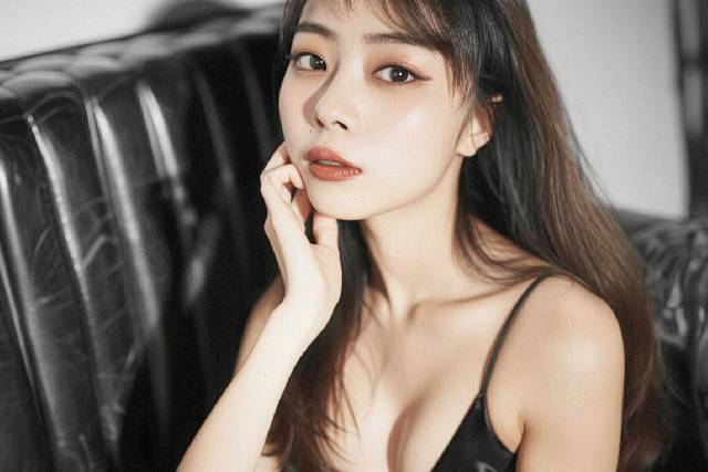 黒いソファーに座り黒いドレスを着た黒寄りのブラウンカラーの髪色をした女性