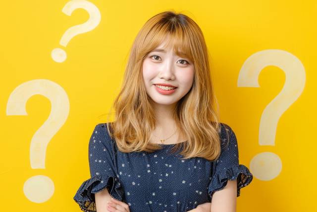 金髪セミロングの女性の背景に複数のクエスチョンマーク