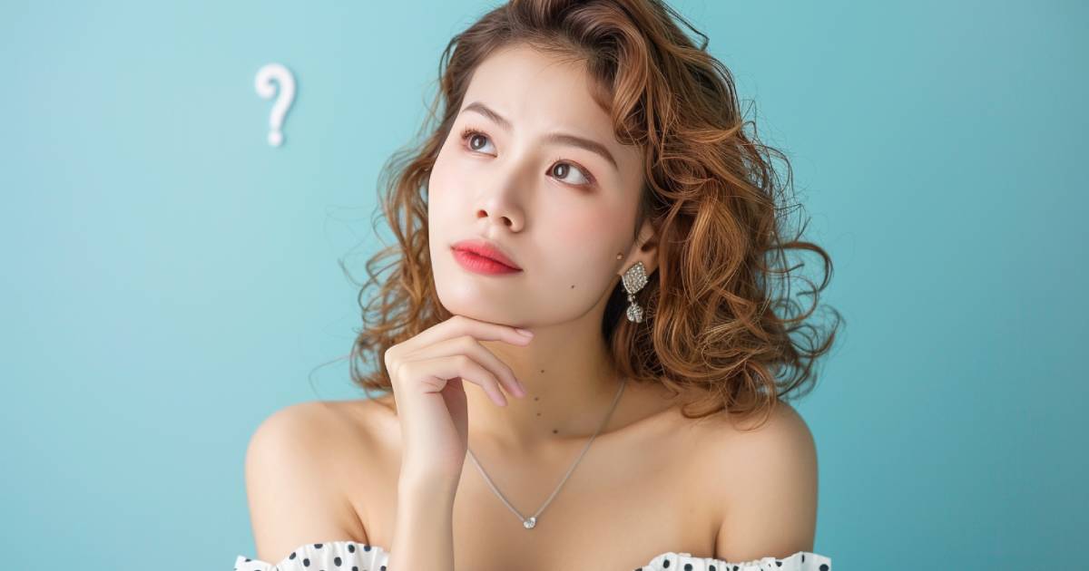 カーリーヘアの女性が右上を見て何かを考えている様子