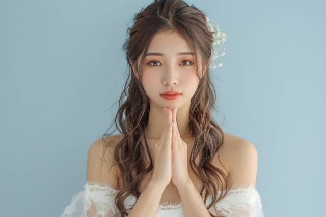 手を合わせて謝罪をする白いドレスの女性