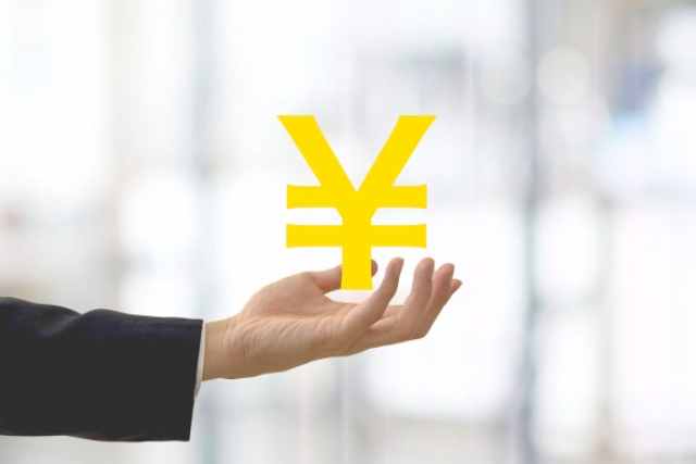 円マークを持つ女性の手