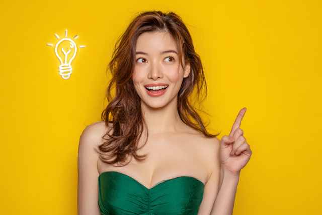 上を指さすドレスの女性