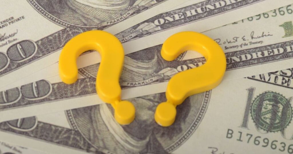 お札の上に置かれた2つの黄色いハテナマーク