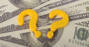 お札の上に置かれた2つの黄色いハテナマーク