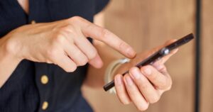 携帯を触る女性の手