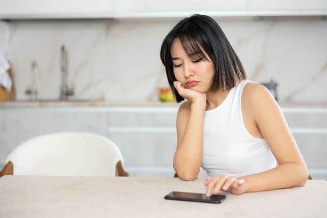 携帯の連絡を待っている女性