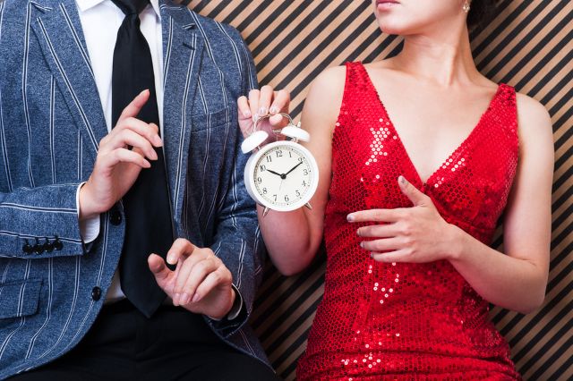 時計を持つ女性と時計を指さす男性