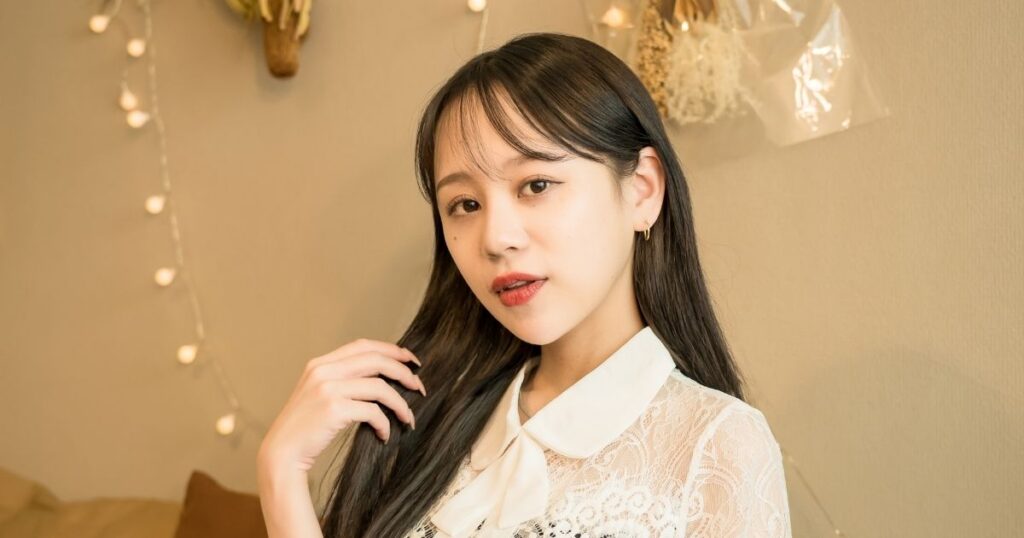 髪を触るロングヘアの女性